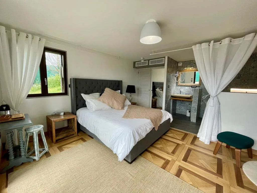 Chambre double lumineuse avec lit Queen Size, parquet et salle de bains ouverte à L'Escondida