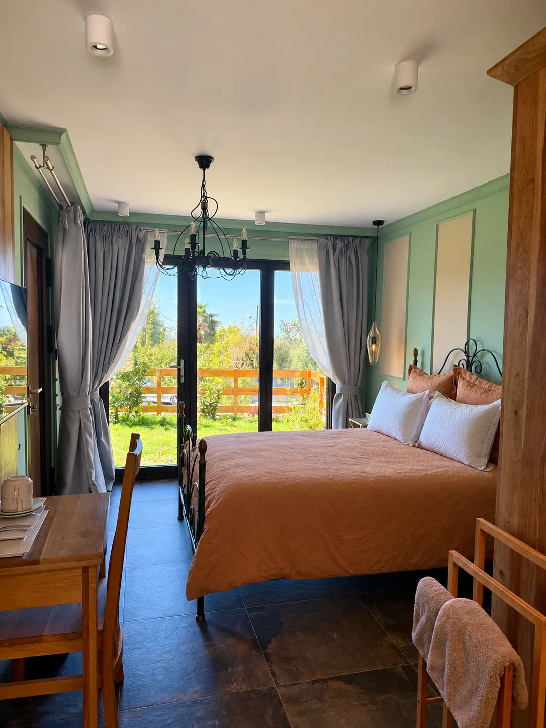 Chambre avec portes-fenêtres ouvrant sur le jardin, lustre noir et bureau en bois à L'Escondida