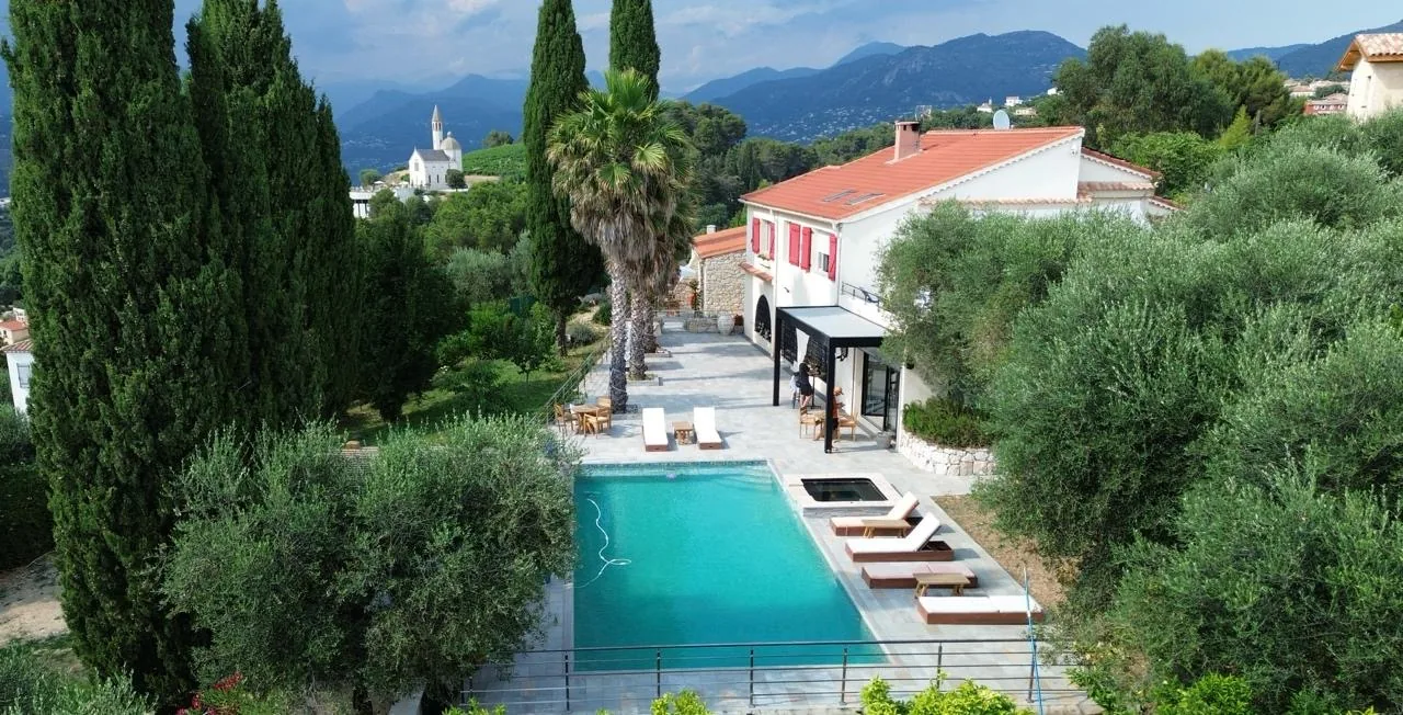 Vue aérienne de la villa, de la piscine et des cyprès face aux montagnes de l'arrière-pays niçois
